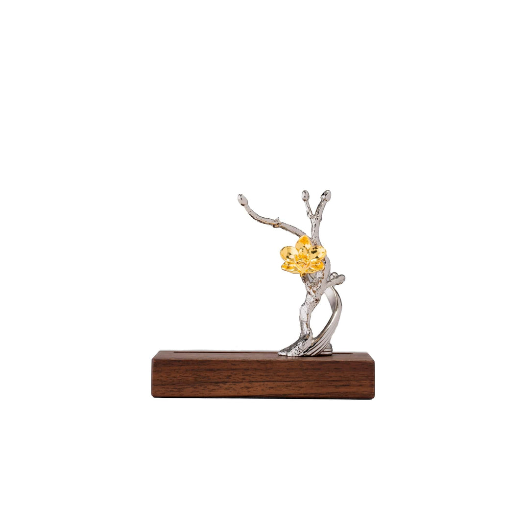 Risis 1974 Doritaenopsis Pen and Name Card Holder - A sculptural silver tree with twisting branches mounted on a dark wood base embraces a vibrant, golden-yellow bloom.