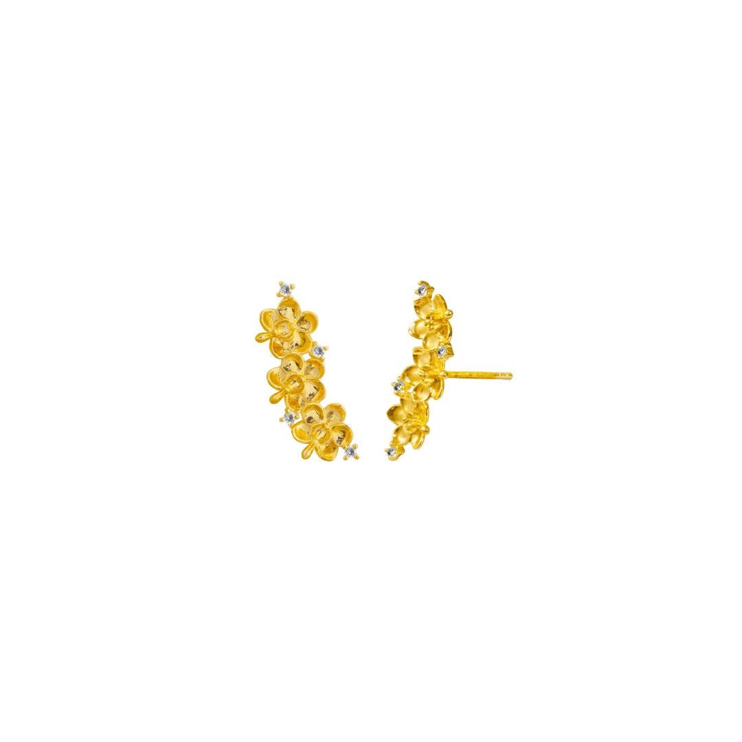Risis Ascocenda Garden Climber Earrings - A person is wearing golden jewelry: intricate stud earrings, a delicate necklace with a floral pendant, and a thin bracelet with similar design details.