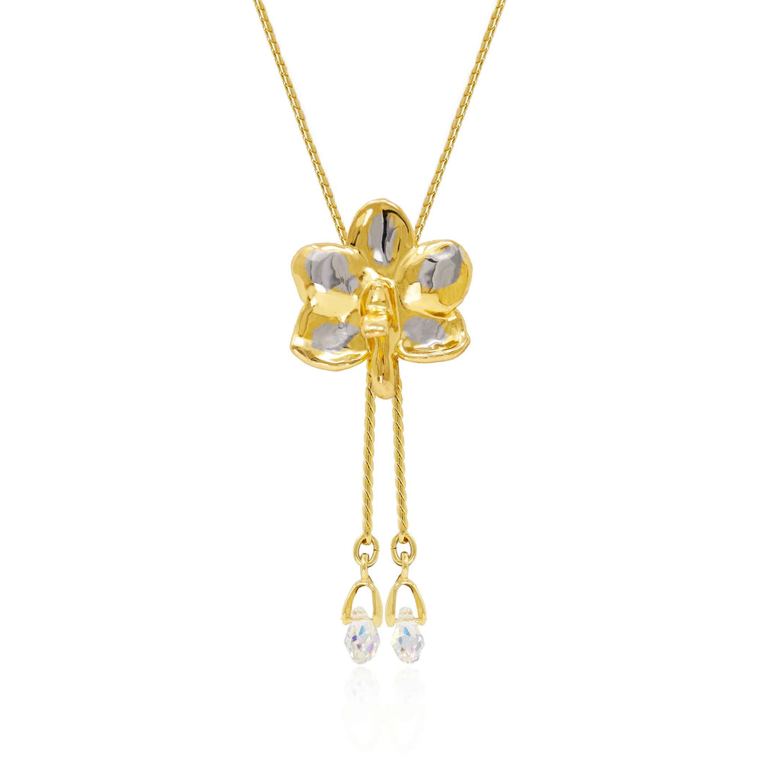 Risis Ascocenda Sagarik Gold Orchid Slider Necklace with Crystal Tailends (PG) - A golden pendant shaped like a four-leaf clover with transparent gemstone inlays hangs from a delicate chain, featuring dangling smaller stones at its base.