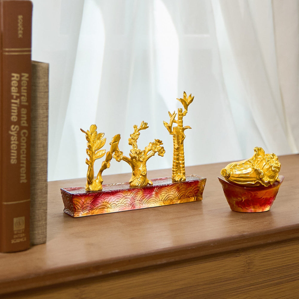 Risis Cabbage on Red Yuan Bao - Golden sculptures resembling trees stand on a red, marbled base, accompanied by a similar small bowl with intricate design details.