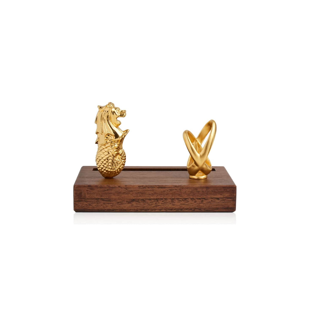 Risis Merlion Infinity Pen And Name Card Holder - A golden dragon and a golden abstract shape rest atop a wooden base, sculpted with intricate detail and a glossy finish.