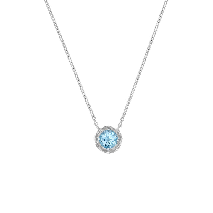 Risis Midori Necklace With Sky Blue Topaz (RH) - A silver necklace with a delicate chain holds a light blue gemstone pendant, encased in an intricate, sparkling setting.