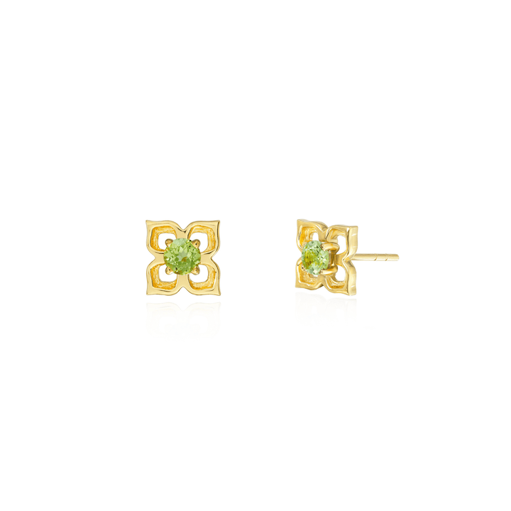 Risis Timeless Peranakan Earrings With Peridot - A pair of gold flower-shaped earrings with a central, faceted, round-cut green gemstone sits gracefully against a reflective surface.