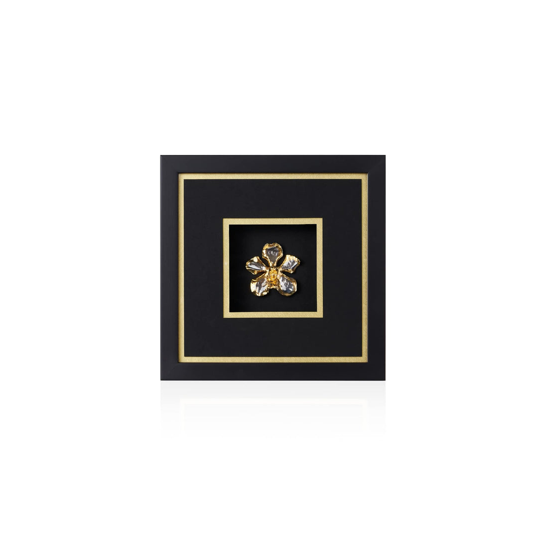 Risis Vanda Orchid Frame II - A golden brooch with petal-like designs and gleaming stones, centered within a black square frame bordered by a gold line, presents an elegant, symmetrical appearance.