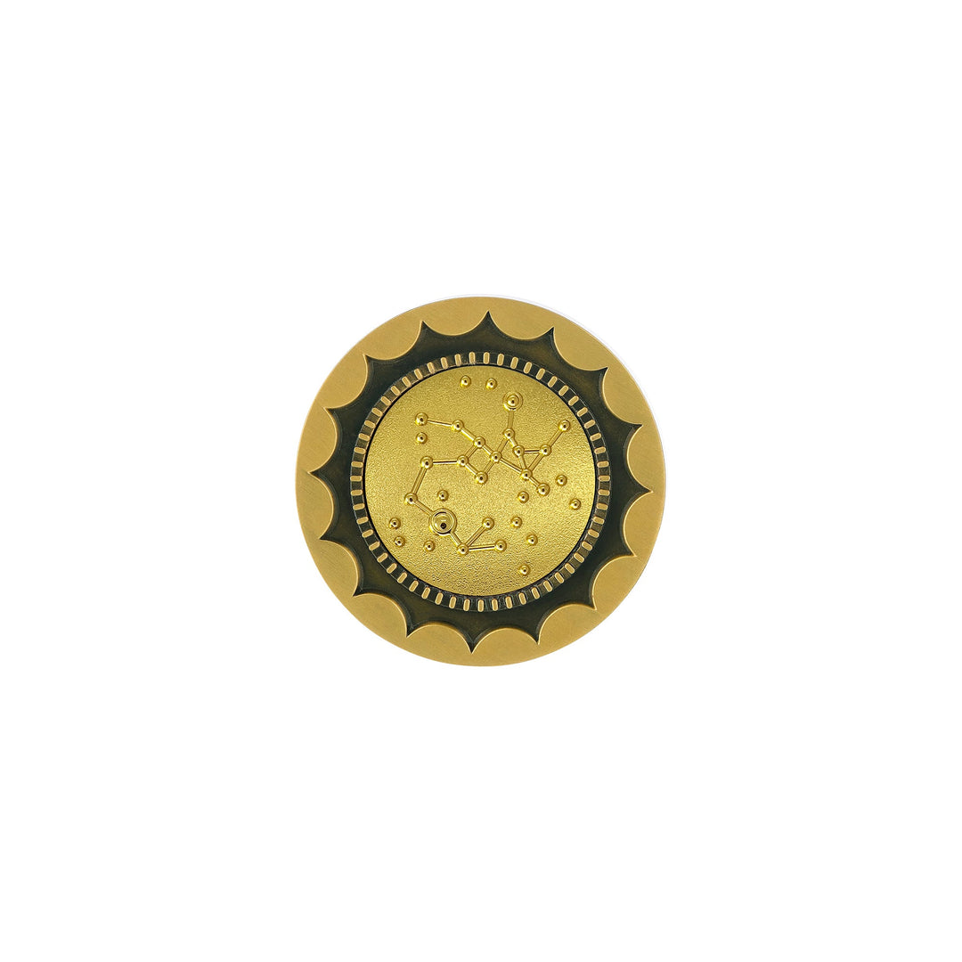 Risis 12 Constellation Base (Sagittarius) - A round, golden-colored medallion with scalloped edges and a zodiac constellation embossed in the center, surrounded by a ring of small dots and gear-like indentations.