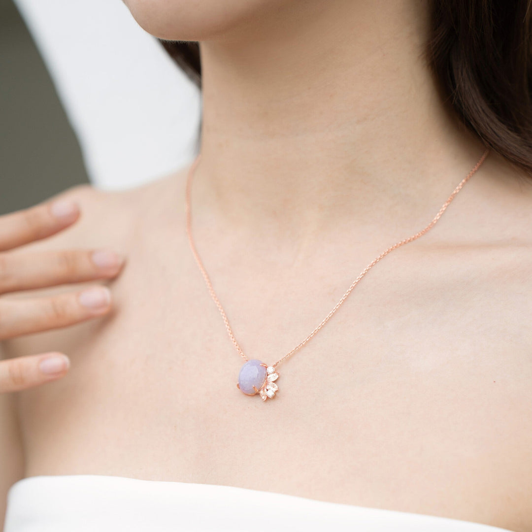 Risis Jadeite Meadows Necklace - A delicate rose gold chain necklace featuring a pale lavender gemstone pendant adorned with a small, elegant flower motif on a light-skinned individual.