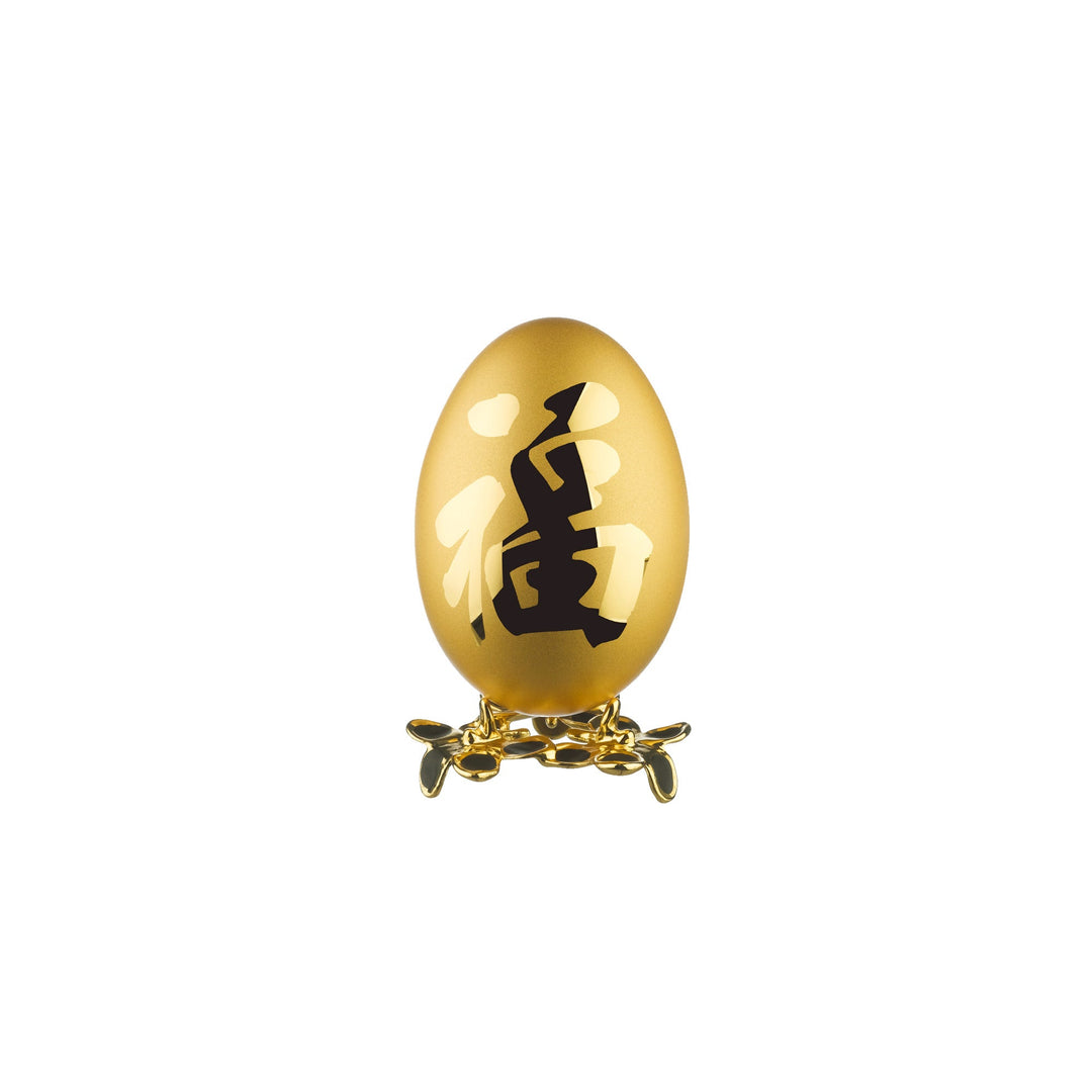 Risis Auspicious Egg - Fu (Medium) - A golden egg with intricate black calligraphy stands on an ornate base. The egg’s surface gleams with a smooth, reflective finish.