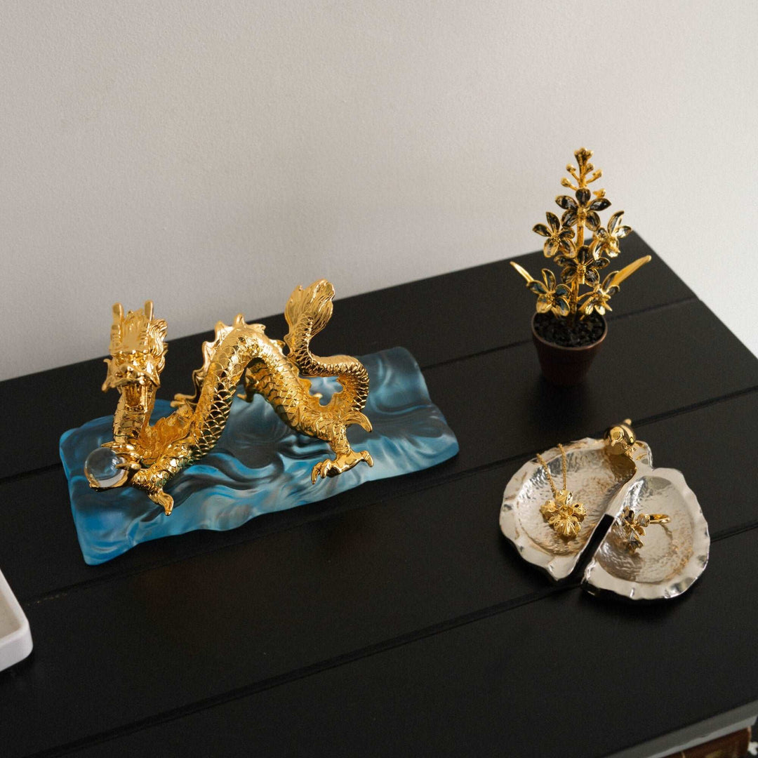 Risis Botanique Chestnut Bird Tray - A silver-colored, leaf-shaped decorative dish with a golden bird perched on the rim, exhibiting a contrast between the sleek silver finish and the bird's glossy gold.