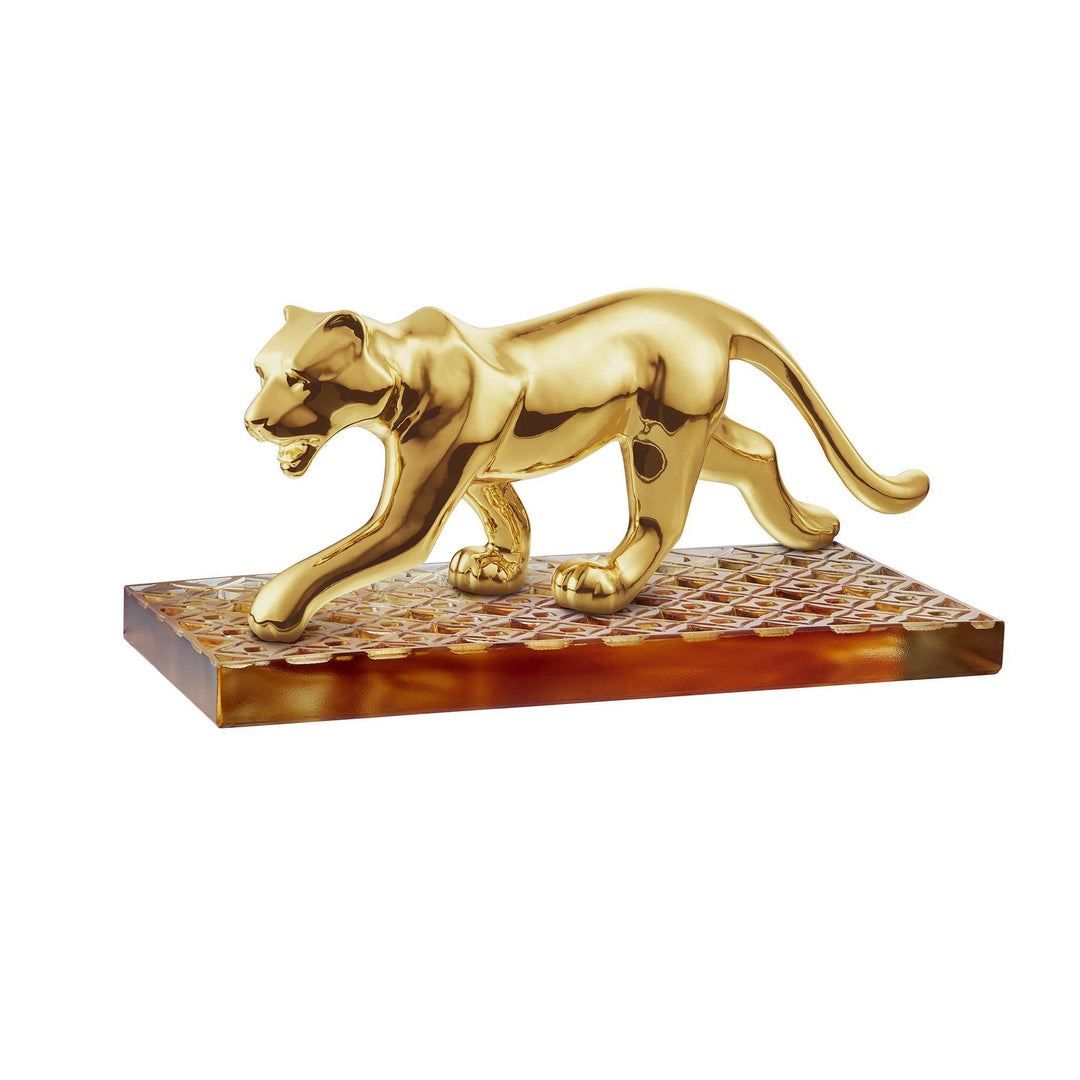 Risis Golden Panther on Amber Liu Li - A golden sculpture of a prowling panther, displaying polished, smooth textures, mounted on a patterned, rectangular base with brownish hues.