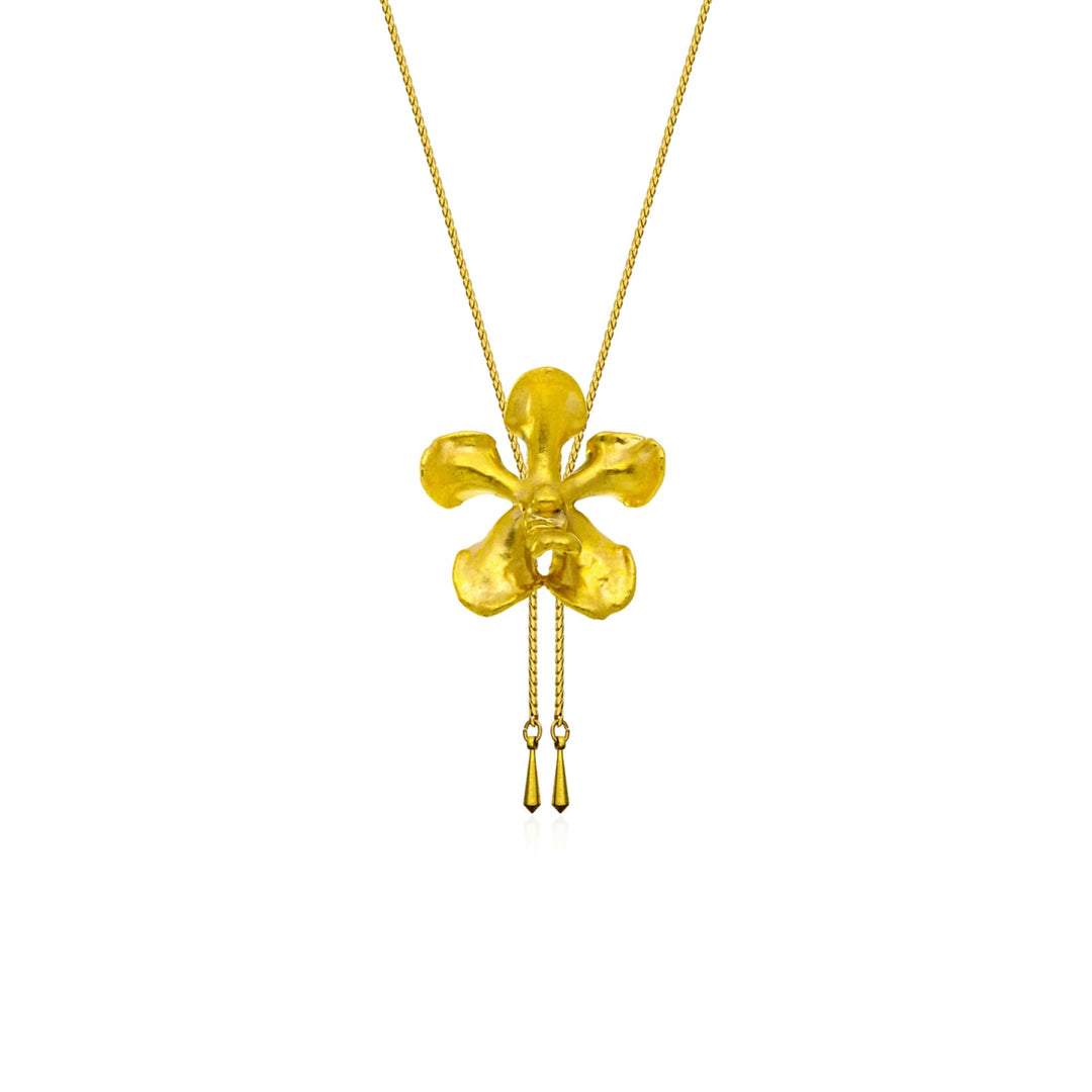 Risis Kagawara Firebird Orchid Slider Necklace (G) - A gold pendant resembling a stylized, four-petaled flower dangles on a thin chain, with two delicate tassels hanging from its bottom.