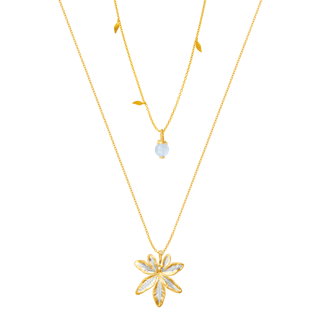Risis Morning Glory Leaf Necklace with Aquamarine and Topaz - A layered gold necklace set with a translucent bead and a larger gold pendant shaped like an embellished flower with five petals, on a simple chain.