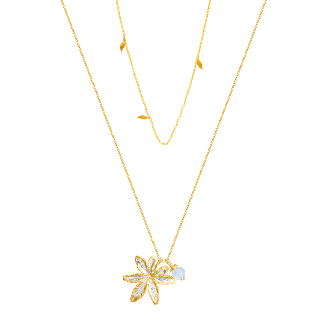 Risis Morning Glory Leaf Necklace with Aquamarine and Topaz - A delicate gold necklace with a detailed, translucent flower pendant and a small, pale blue bead hanging beside it.