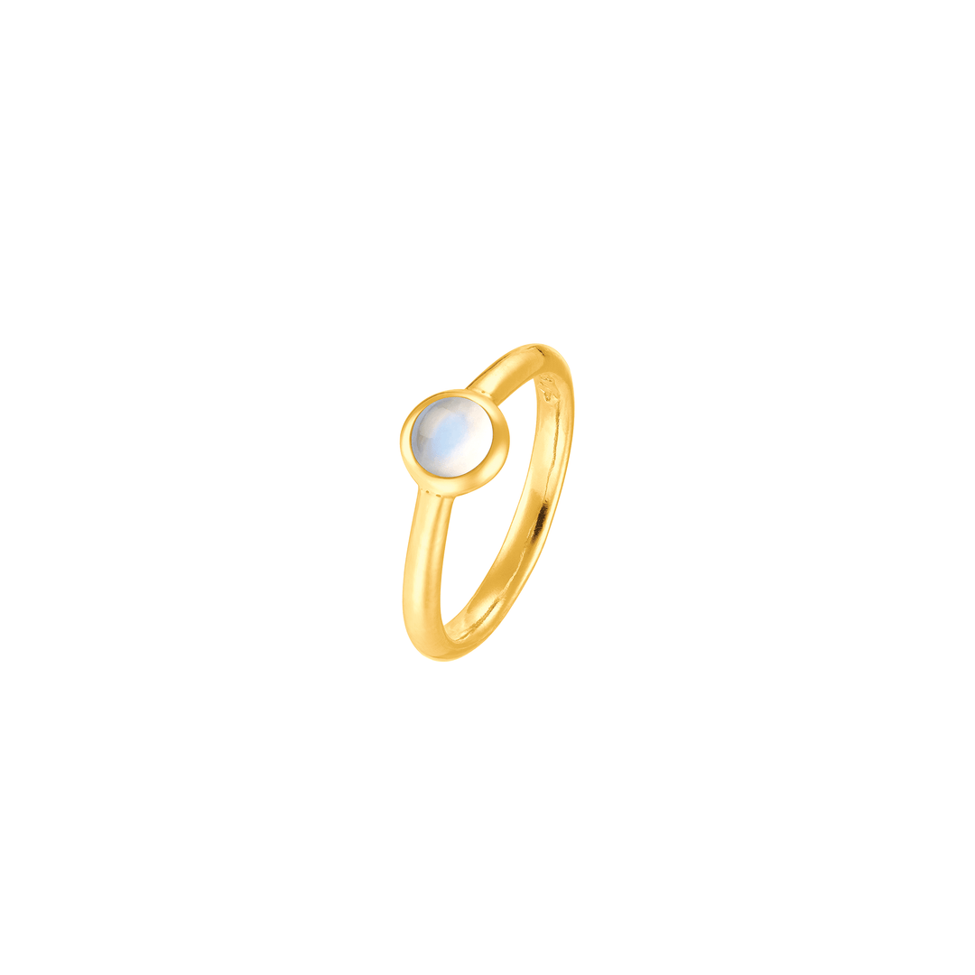 Risis Peranakan Jewel Ring with Moonstone - A slender gold ring with a lustrous, round opalescent gemstone set atop, capturing hues of blue and white as it reflects light.