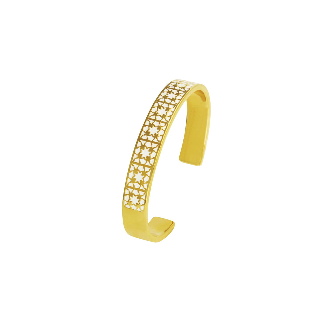 Risis Peranakan Orchid Bangle with White Enamel - A golden cuff bracelet with a band of star-shaped cut-outs creating an elegant pattern. The finish is shiny, catching light and drawing attention to the intricate design.