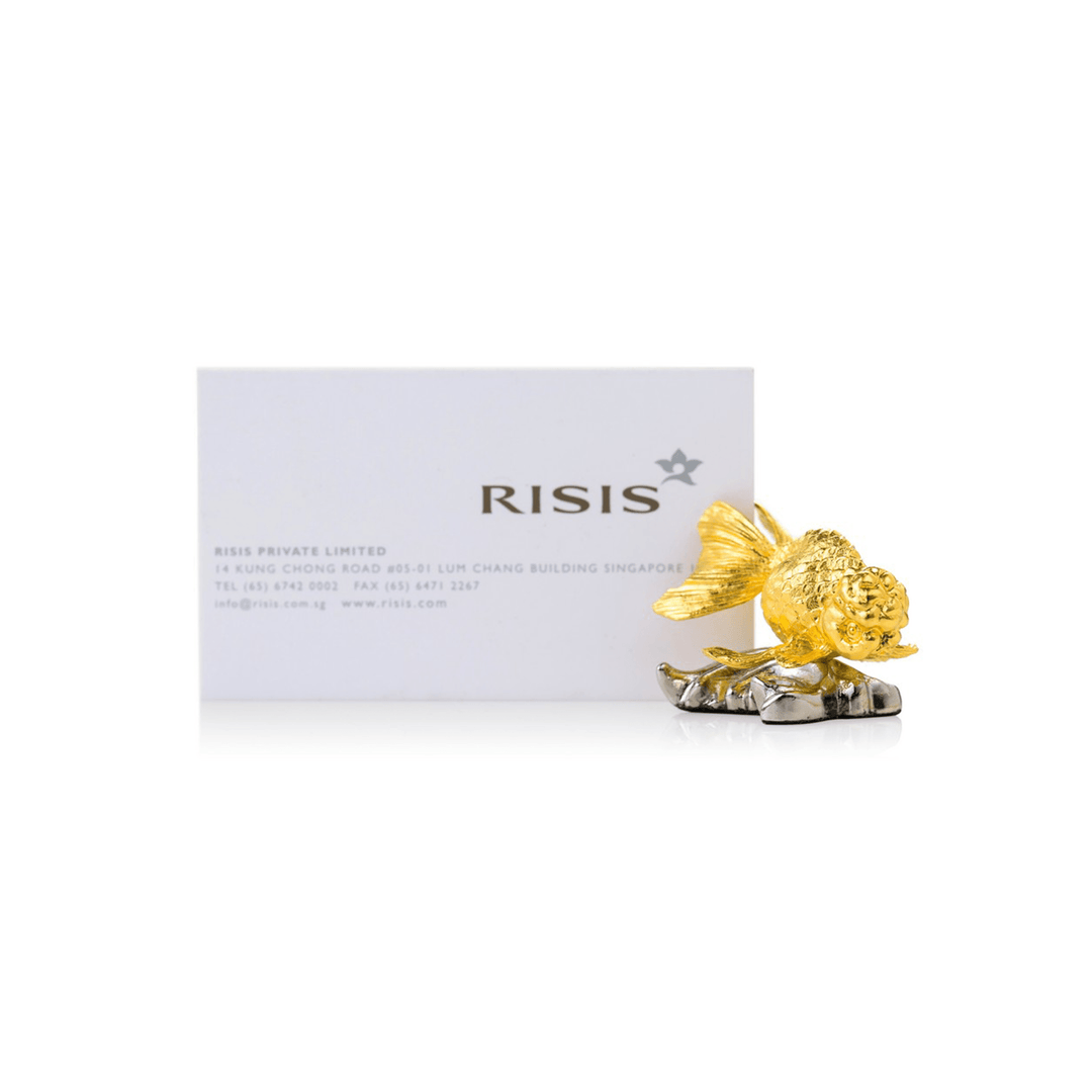 Risis Ranchu Goldfish Name Card Holder (Small) - A golden ornamental fish with intricate detailing sits on a metallic base, exuding elegance and craftsmanship. The sculpture is positioned in front of a business card.