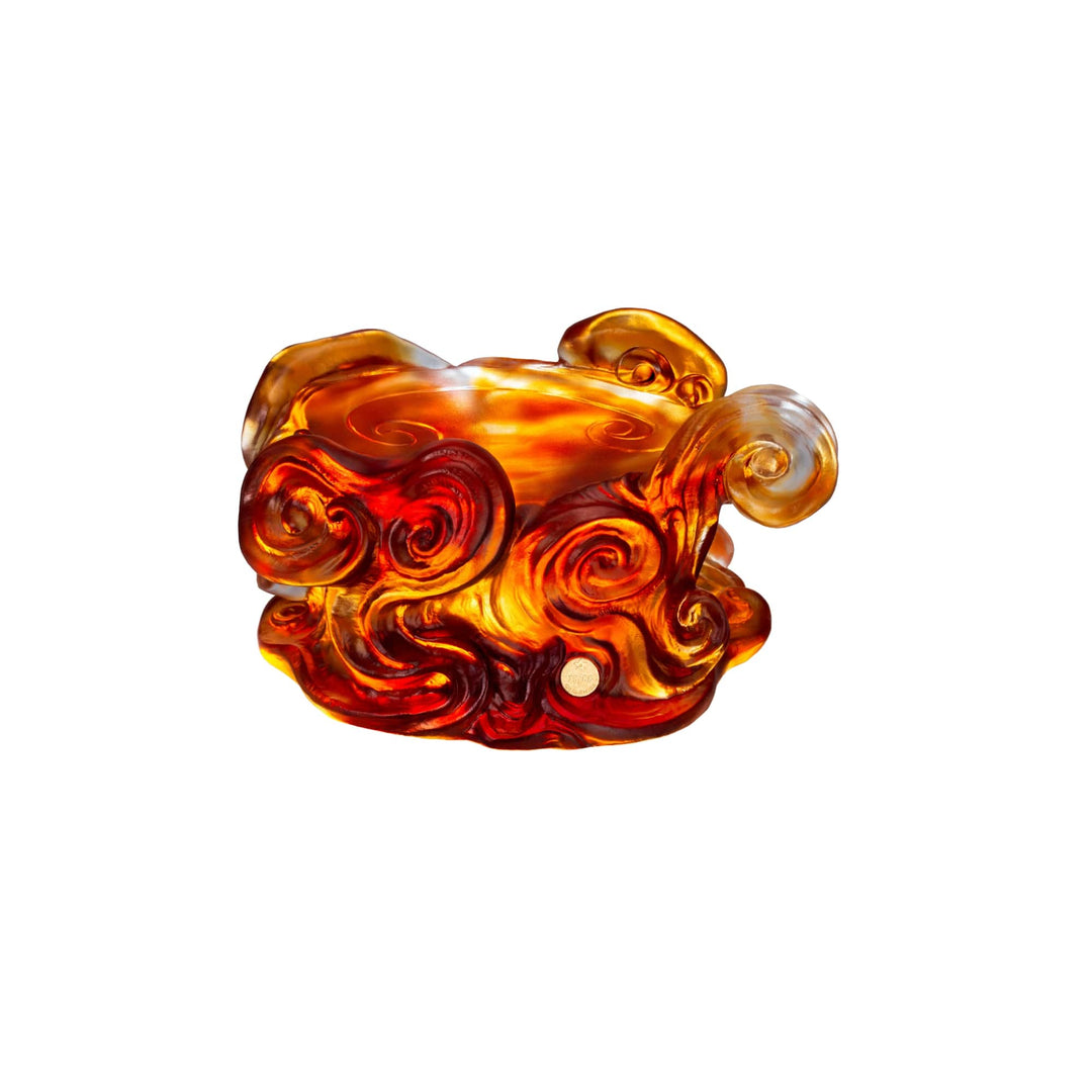 Risis The Imperial Dragon on Amber Liu Li - An ornate, amber-colored glass object with intricate swirls and translucent quality, resembling stylized flames or curls.