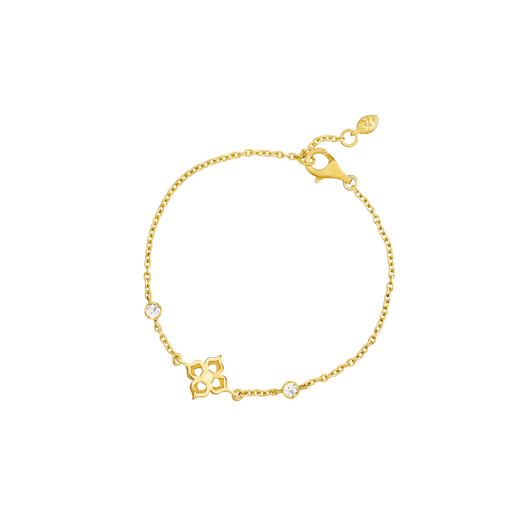 Risis Timeless Peranakan Bracelet with White Topaz - A delicate gold bracelet features a fine chain, with small, clear gemstones and intricate charms interspersed along its length. It exhibits a polished, elegant design.