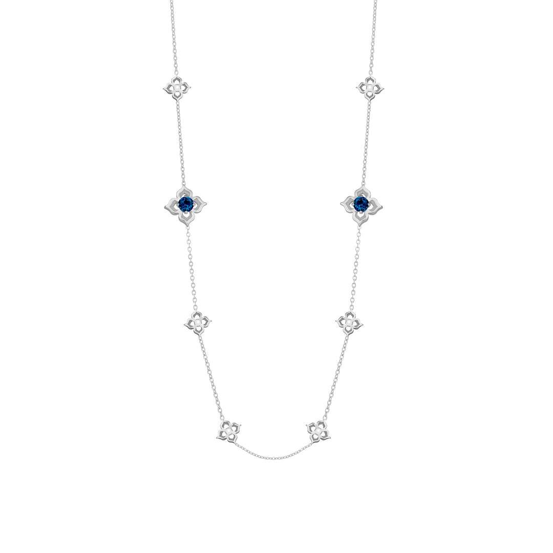 Risis Timeless Peranakan II Necklace (RH) with London Blue Topaz - A silver necklace showcasing a symmetrical design with embedded dark blue stones centered in star-shaped settings, connected by delicate chain links.
