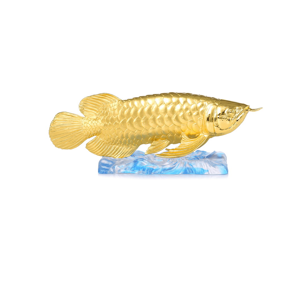 Risis Treasure Arowana - A golden fish sculpture with detailed scales and fins is perched atop a translucent blue wave-like base, creating an impression of motion and elegance.