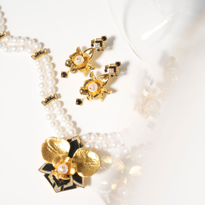 Gold-tone pearl necklace with black enamel flower cluster pendant and studded accents