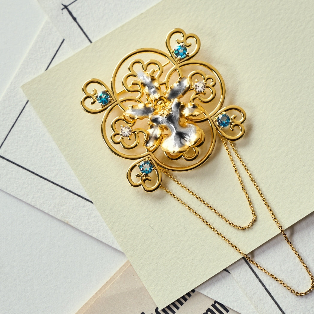 RISIS Peranakan Oncidium Orchid Brooch in Gold and Palladium with White and Blue Topaz