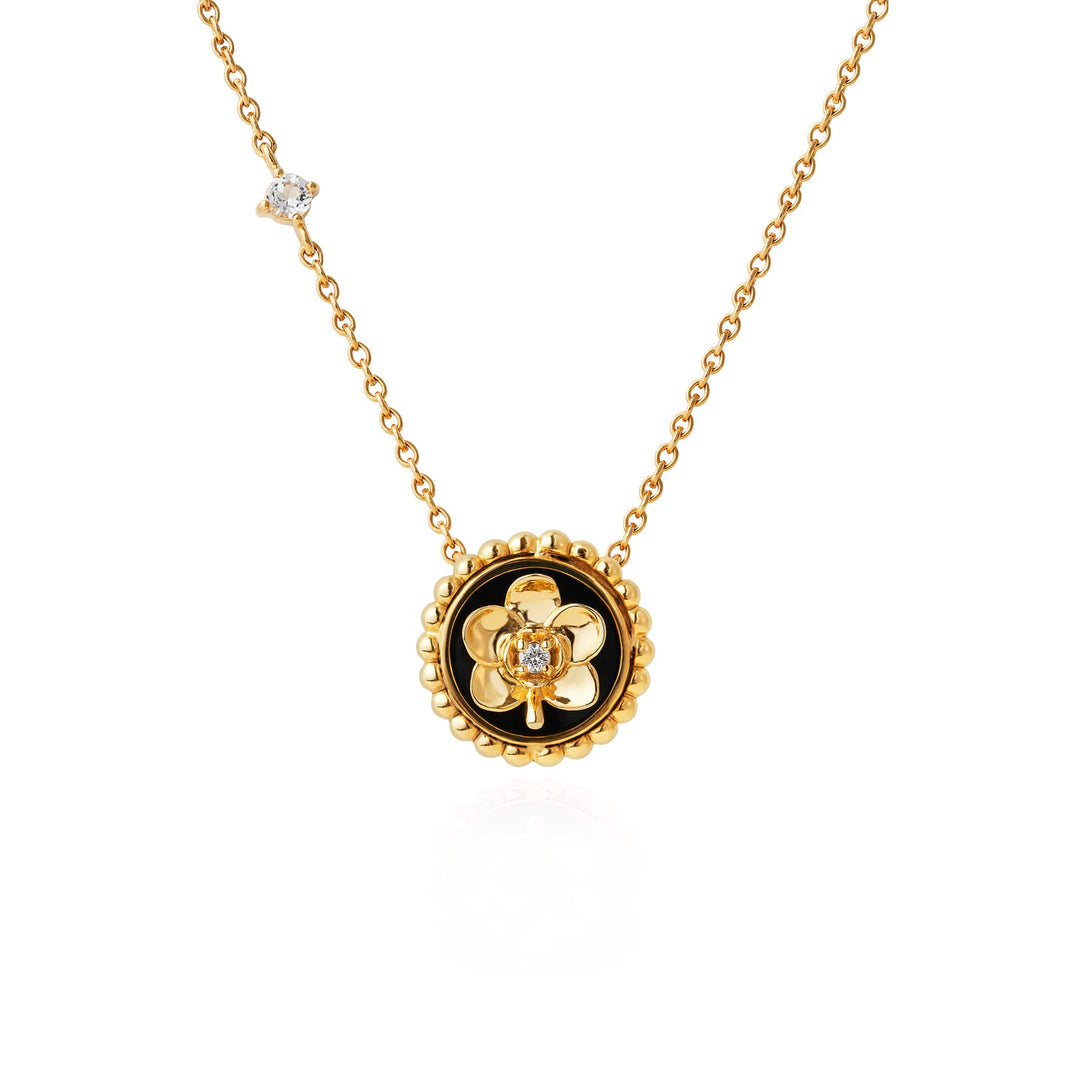 Risis Beaded Ascocenda Necklace - A golden necklace with a central flower-shaped pendant featuring a small gemstone at its core, complemented by a solitary gem along the chain.