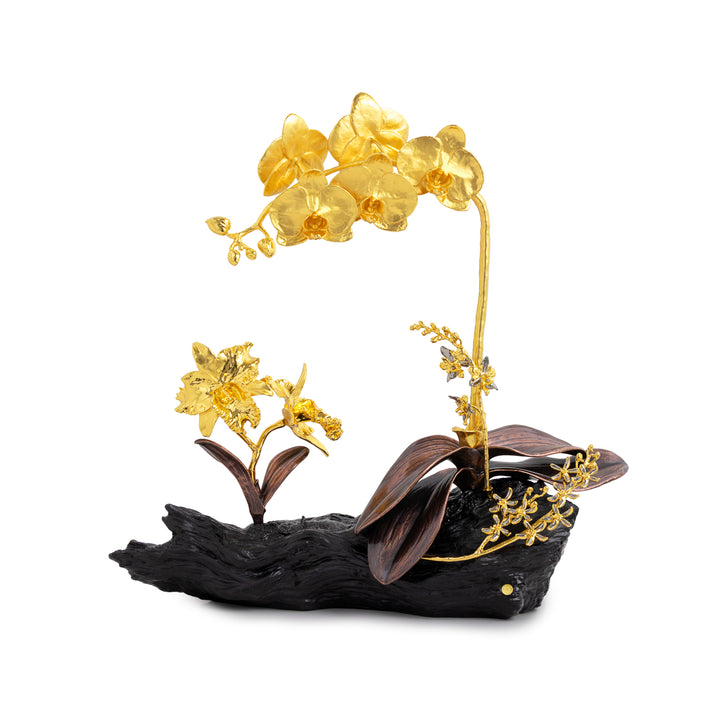 Gold-plated artificial orchid flowers with dark brown leaves and a black driftwood-style base, photographed on a clean white background.