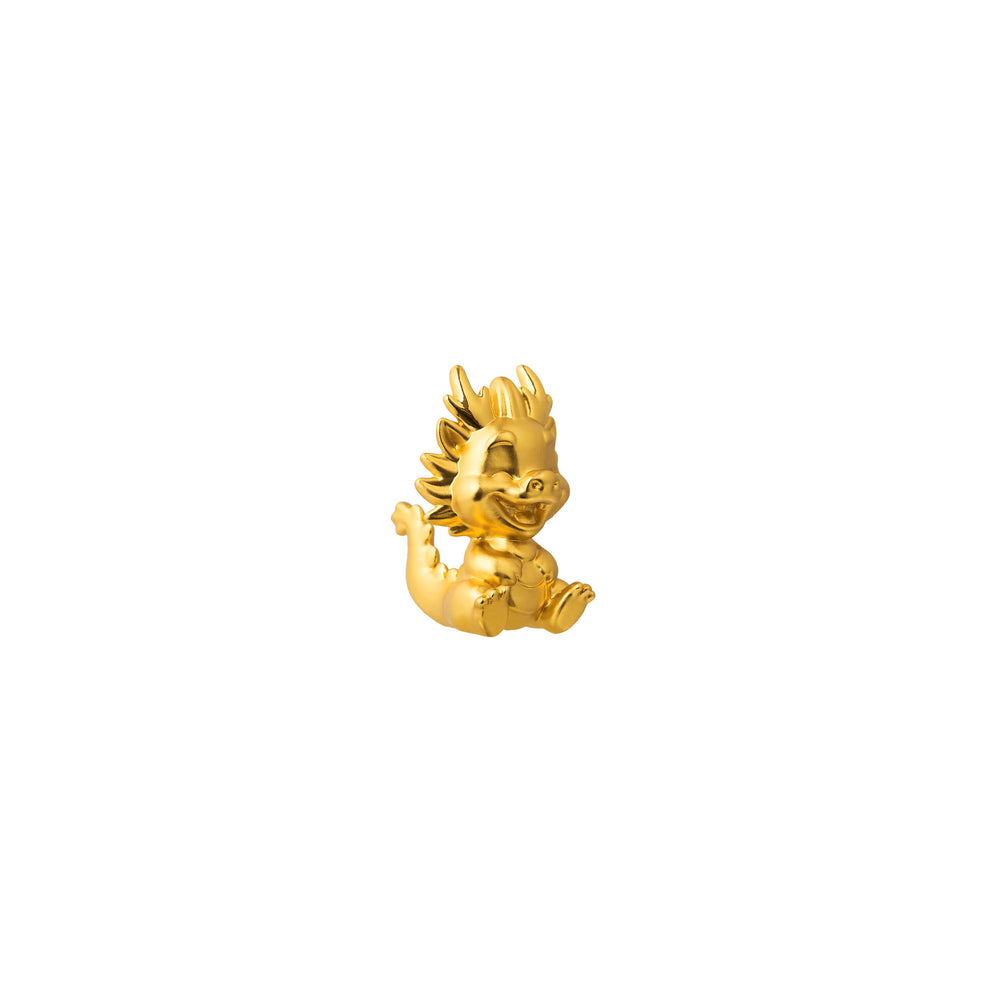 Gold-tone dragon figurine in side view, spiky mane and curved tail detail.