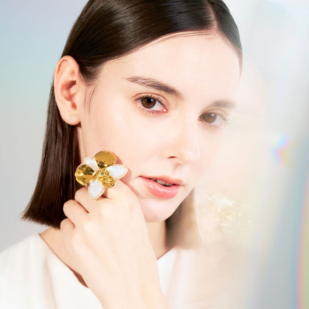 Orchid ring with mother-of-pearl petals and pavé diamonds on finger