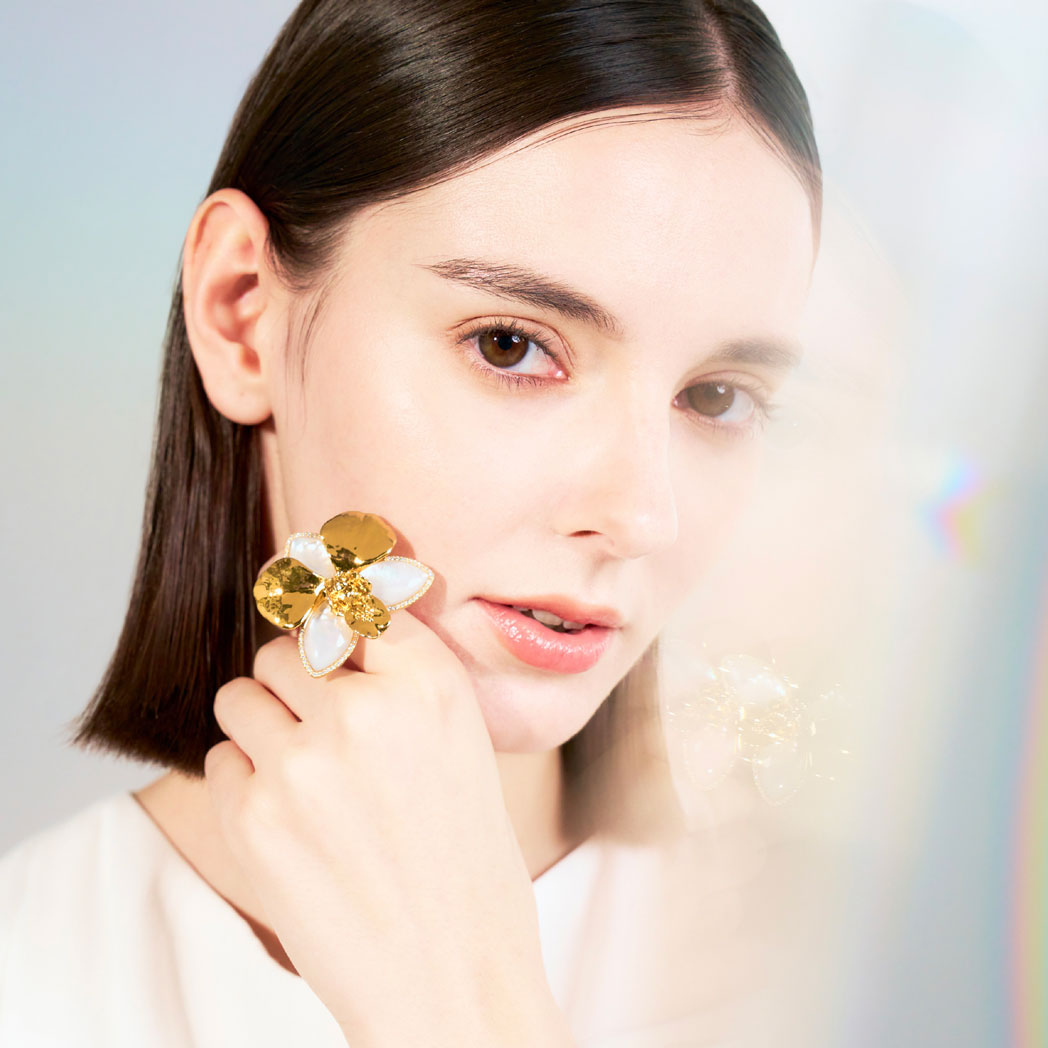 Orchid ring with mother-of-pearl petals and pavé diamonds on finger