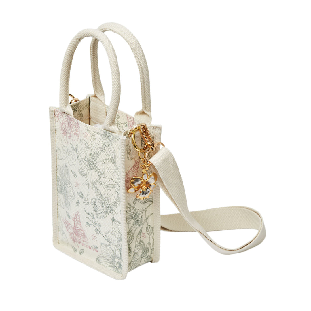 RISIS Orchid Canvas Mini Tote Bag. Designed for versatility, the bag comes with an optional strap, allowing for an effortless transition from handheld to crossbody wear.