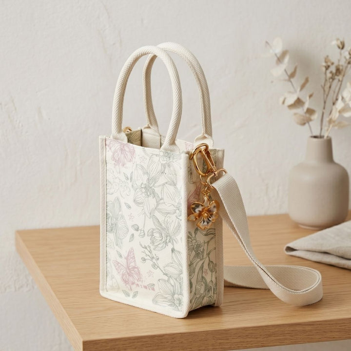 RISIS Orchid Canvas Mini Tote Bag. Designed for versatility, the bag comes with an optional strap, allowing for an effortless transition from handheld to crossbody wear.