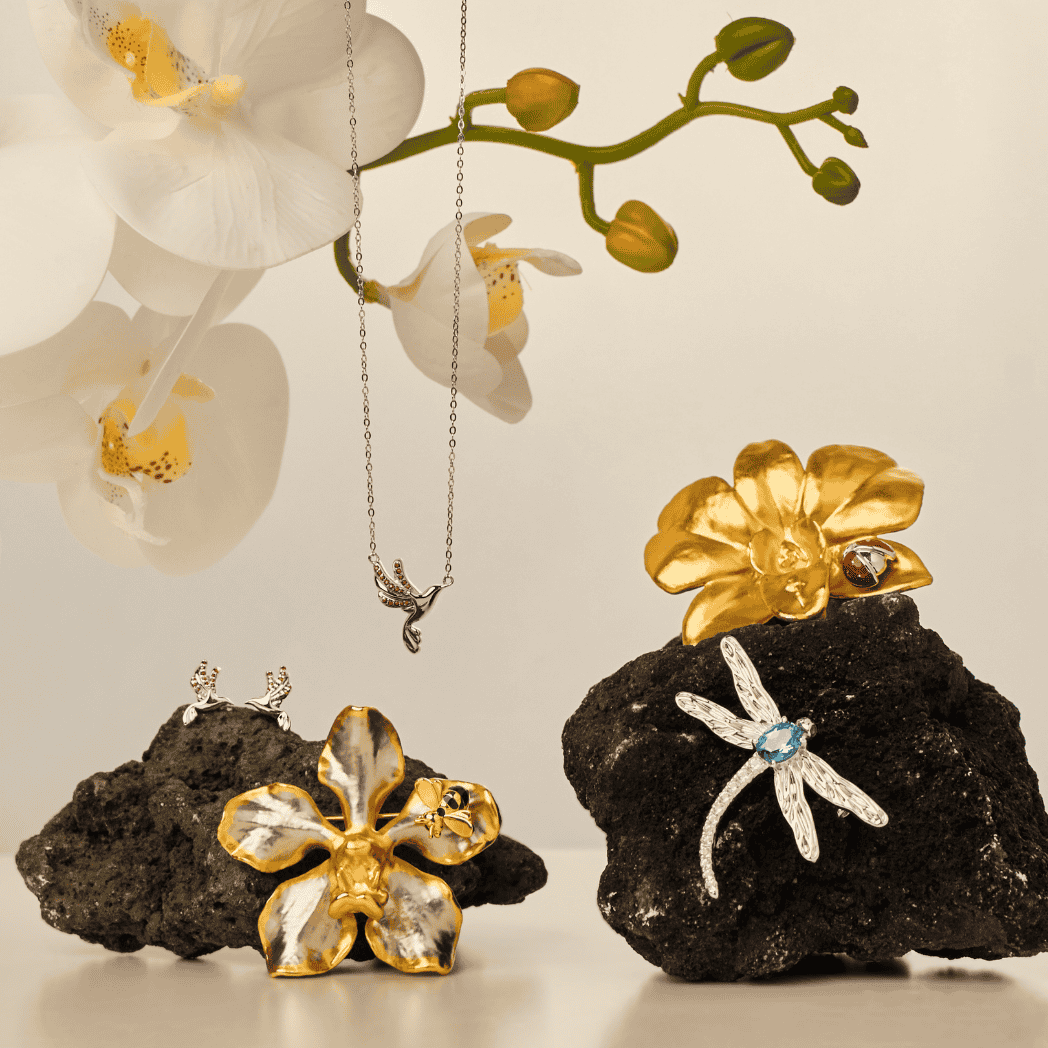 RISIS Sunbird Whispers Necklace and Earrings - 925 sterling silver in Rhodium with Red Garnets; RISIS Natural Vanda Orchid Bee-on-Brooch encapsulated in 24K Swiss Gold and Palladium; RISIS Sunbird Whispers Necklace and Earrings - 925 sterling silver in Rhodium with Red Garnets; RISIS Natural Vanda Orchid Bee-on-Brooch encapsulated in 24K Swiss Gold and Palladium