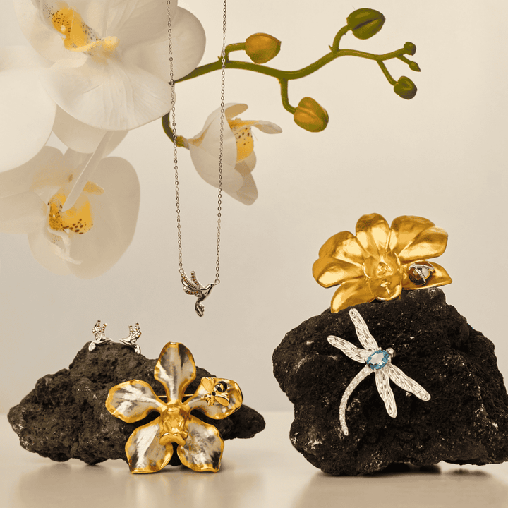 RISIS Sunbird Whispers Necklace and Earrings - 925 sterling silver in Rhodium with Red Garnets; RISIS Natural Vanda Orchid Bee-on-Brooch encapsulated in 24K Swiss Gold and Palladium; RISIS Sunbird Whispers Necklace and Earrings - 925 sterling silver in Rhodium with Red Garnets; RISIS Natural Vanda Orchid Bee-on-Brooch encapsulated in 24K Swiss Gold and Palladium