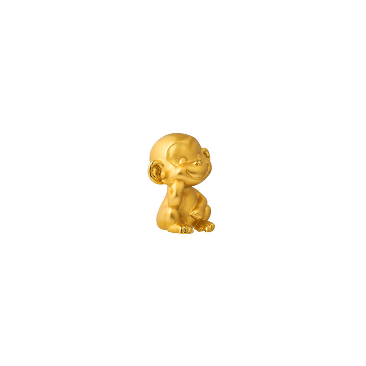 Gold-tone monkey figurine in profile pose with smiling face