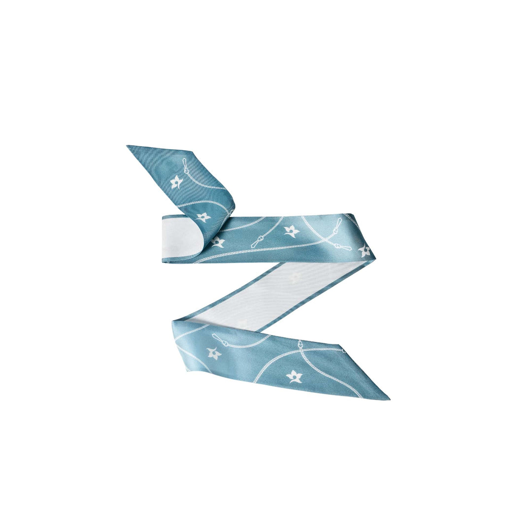 Risis - A light blue folded paper airplane patterned with simple white symbols such as stars and paperclips, suspended in isolation.