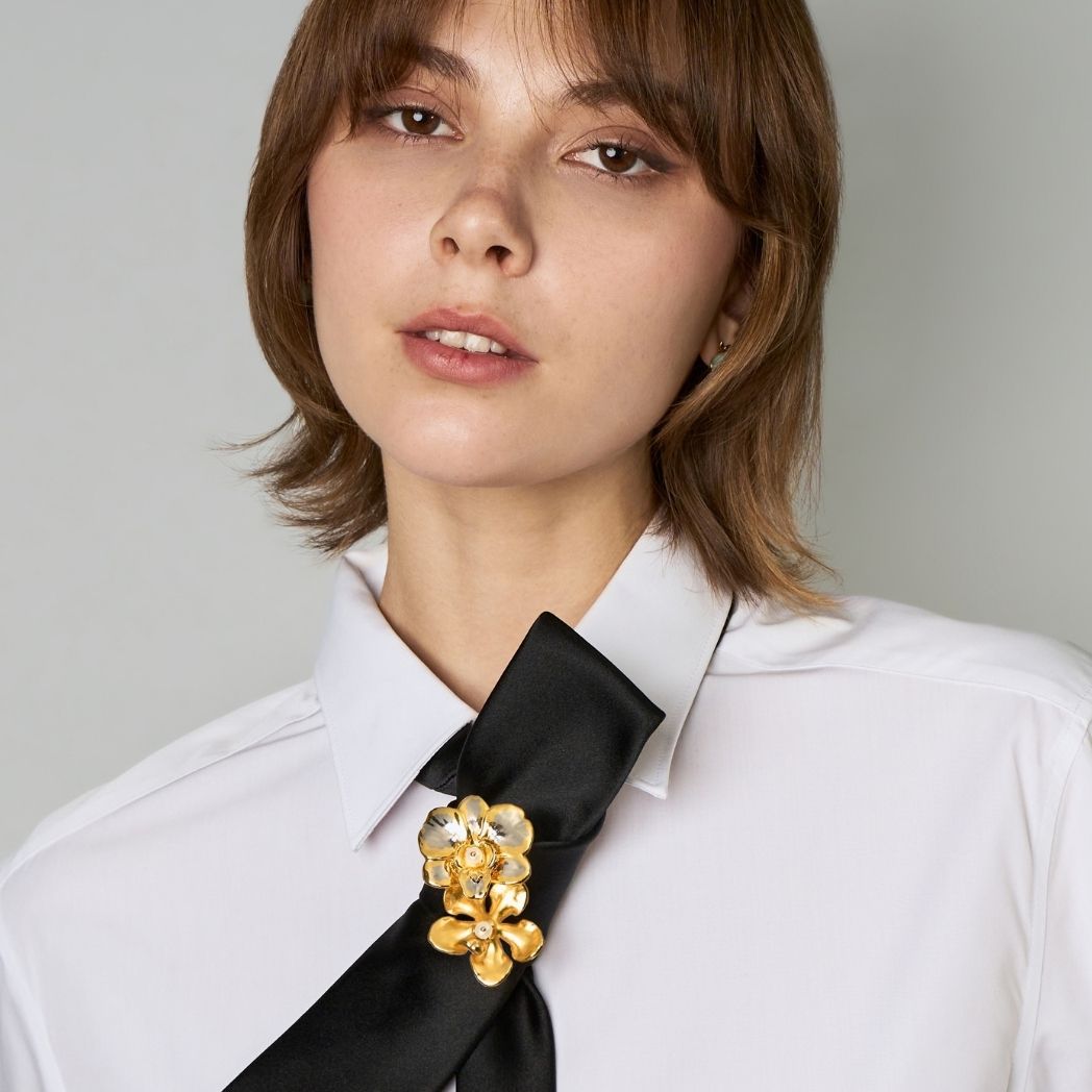 Gold-tone orchid brooch on black ribbon tie, floral cluster detail