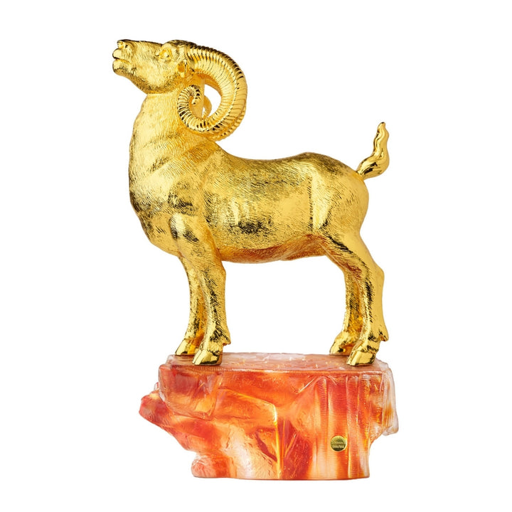 Golden standing argali figurine with coiled horn and amber-colored carved base