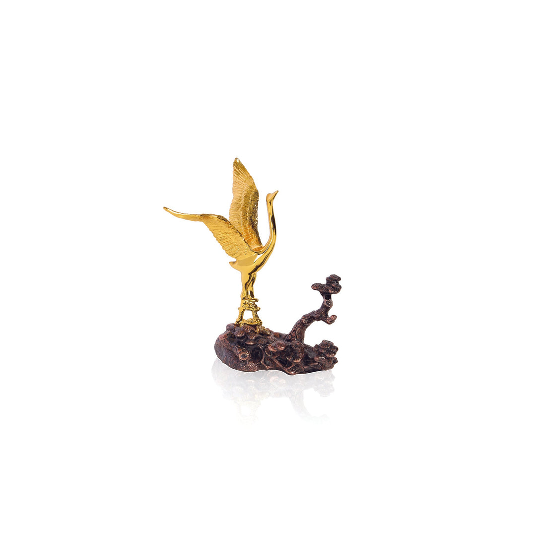 Risis Auspicious Crane on Pine - A golden bird with open, textured wings majestically ascends from a rugged, bronze-toned base, creating an elegant contrast and evoking a sense of graceful movement.