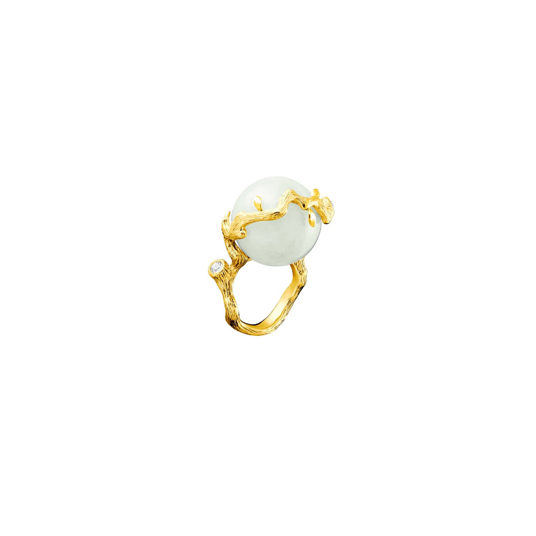 Risis Banyan Vines Jade Ring - A golden ring featuring textured branches cradling a large, luminescent white orb, accented by a small, inset crystal near the band's base.