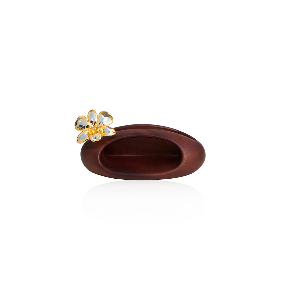 Risis Dendrobium Orchid Phone Amplifier And Pen Holder - A sleek, polished wood hairpin features an ornamental golden flower with translucent petals and a reflective center, depicting elegance and simplicity.