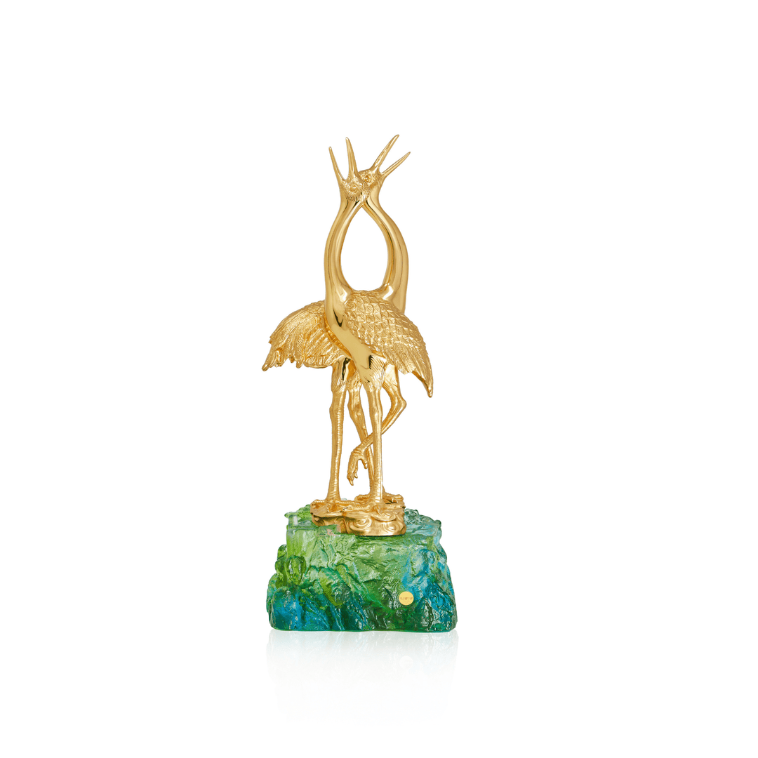 Risis Double Crane on Liu Li - Golden crane statuette with outstretched wings, perched atop a vivid green and blue crystal base resembling water with aquatic plants.