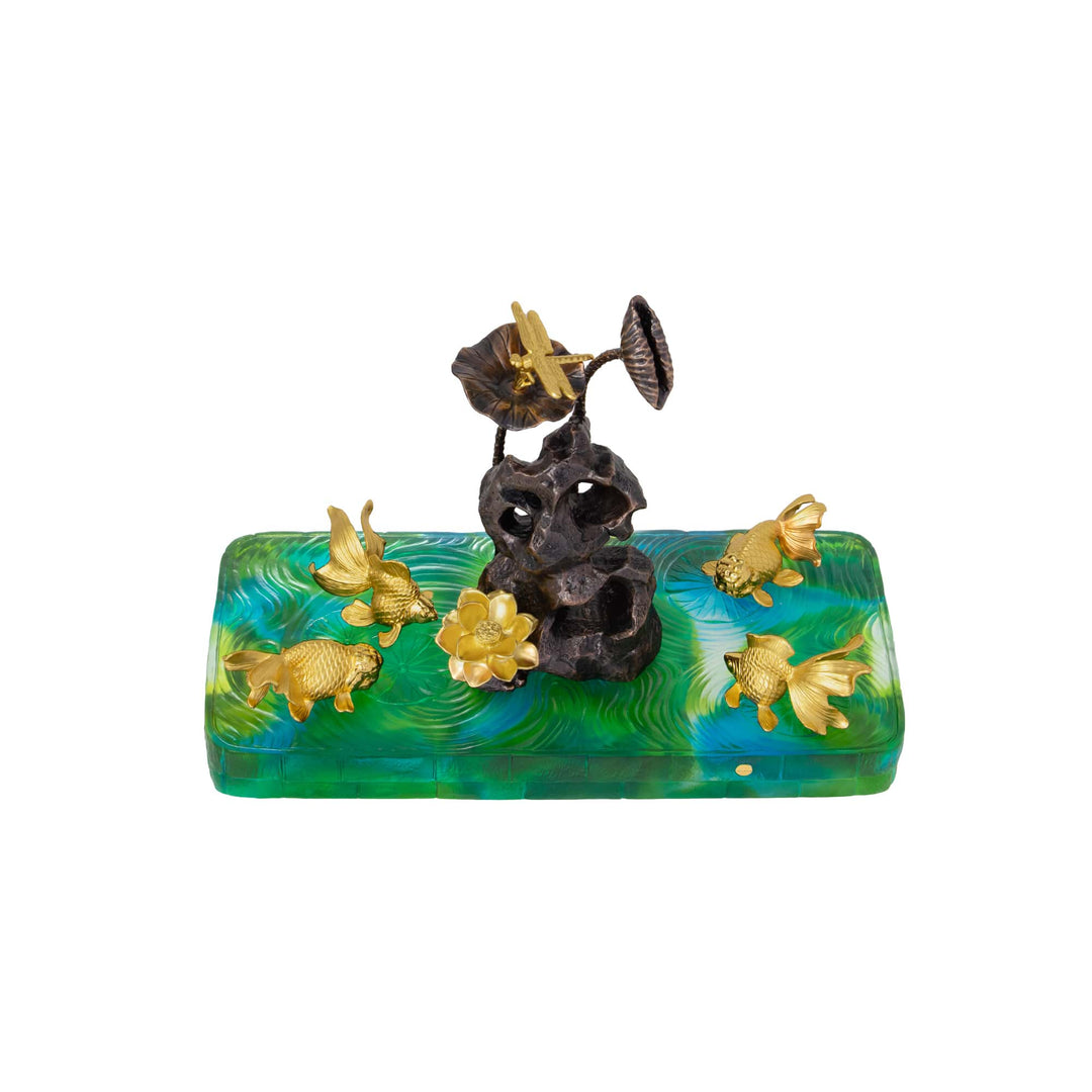 Risis Harmony Dragonfly And Lotus Pond On Liu Li - A decorative sculpture featuring a textured, dark stone with gold-colored flowers and mushrooms atop a vibrant, swirling blue and green base with gold fish leaping around the perimeter.
