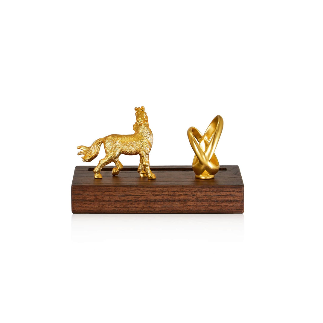 Risis Horse Infinity Pen And Name Card Holder - A golden, textured lion statue and an abstract, smooth golden ornament sit atop a dark wooden base. Both exude a shiny, metallic finish.