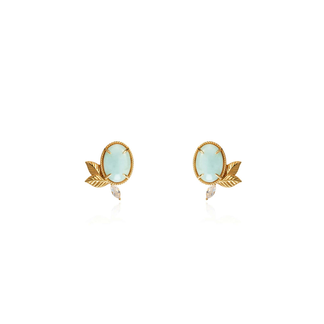 Risis Jadeite Prairie Earrings - A pair of gold-tone earrings, each with a pale blue oval gemstone set in a beaded bezel, flanked by a small leaf motif and clear teardrop crystal below.