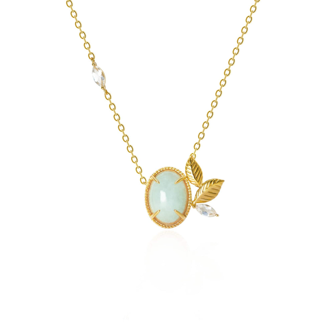 Risis Jadeite Prairie Necklace - A delicate gold necklace with a pale green oval gemstone pendant, adorned with gold leaf motifs and a small clear crystal accent.