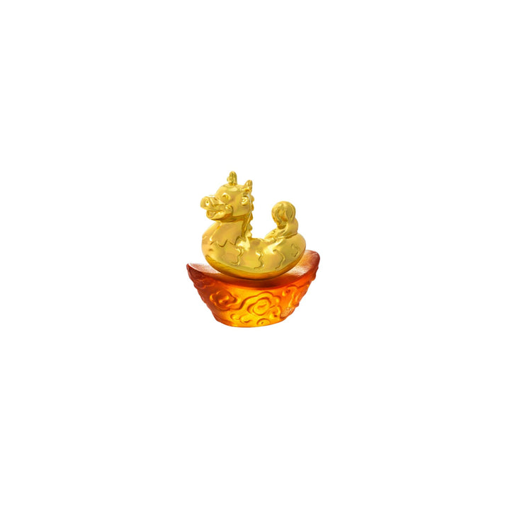 Risis Mini Celestial – Dragon on Amber Liu Li - A golden dragon sits atop a rich, amber-hued base with intricate, swirling patterns. The piece conveys a playful and ornate aesthetic.