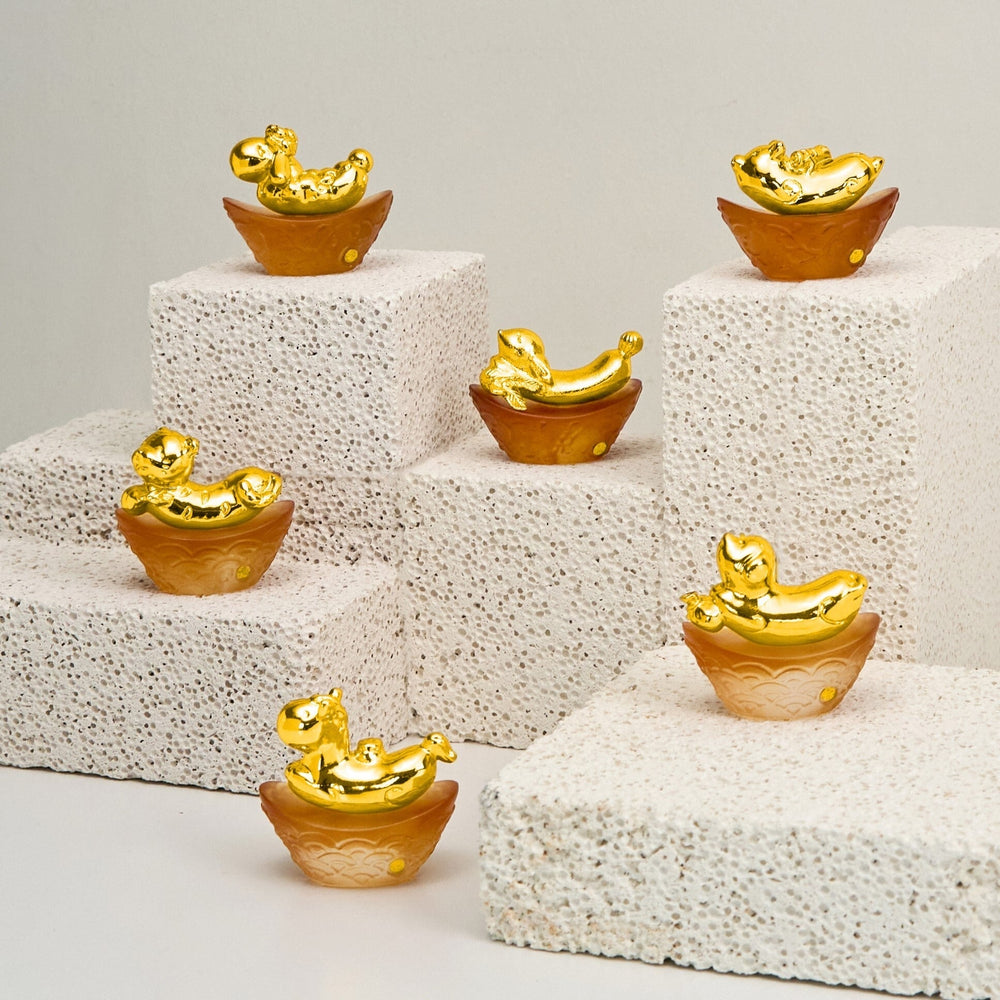 Risis Mini Celestial – Tiger on Amber Liu Li - Seven small gold and amber-colored decorative dishes are arranged on white steps, each resembling a tiny boat with ornate, curled details and a glossy finish.