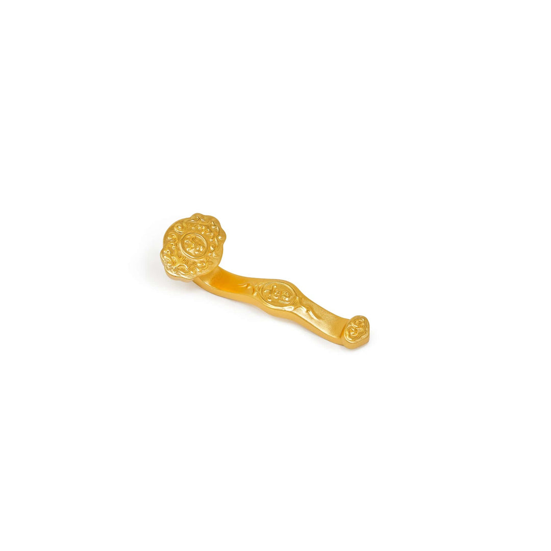 Risis Ruyi Scepter II - An ornate golden scepter with intricate designs and a round, embossed end, lying on a plain surface.
