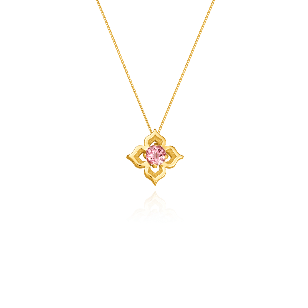 Risis Timeless Peranakan Necklace With Pink Tourmaline - A golden pendant in a stylized floral design, featuring a pink gemstone at the center, hangs from a delicate chain.
